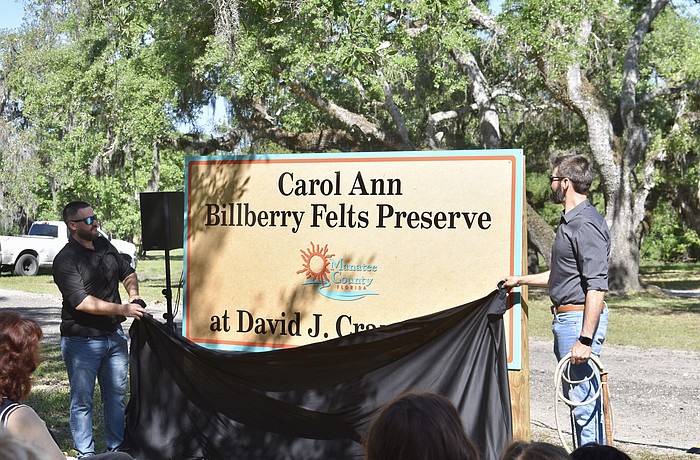 Carol Ann Felts' sons Kiel and Nicholas Felts unveil the new sign at David J. Crane Park.