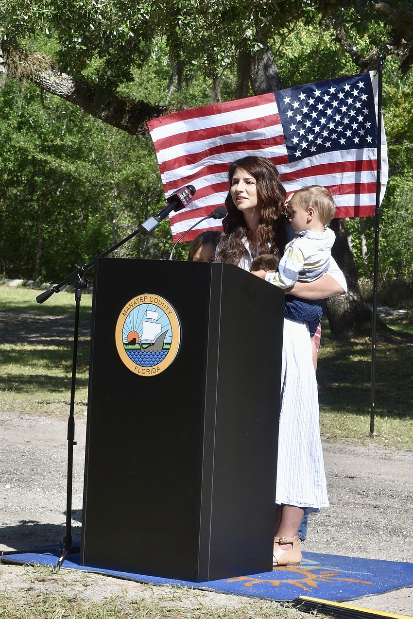 Commissioner Amanda Ballard holds her youngest son as she speaks to the crowd. 