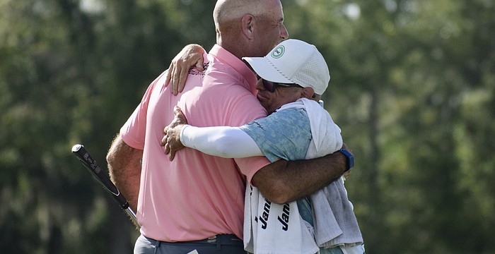 Stewart Cink (left) embraces his caddie after winning the Senior PGA Championship on April 19 at The Concession Golf Club. It marked his first major title on the PGA Tour Champions.