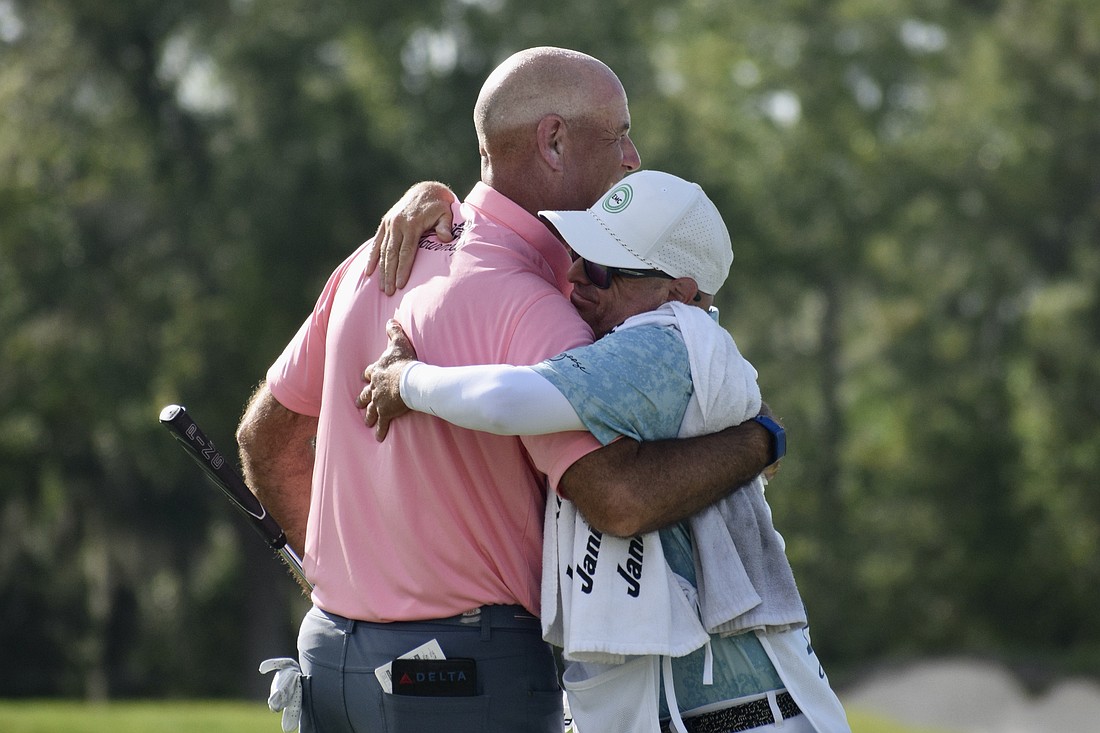 Stewart Cink (left) embraces his caddie after winning the Senior PGA Championship on April 19 at The Concession Golf Club. It marked his first major title on the PGA Tour Champions.