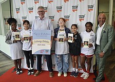 Sixth grader Jaleeyah, seventh grader Arianny, Young Chefs Academy owner Dennis O'Sullivan, seventh grader Meadow, fifth grader Ryker, fourth grader Mia, and Bill Villafranco, a trustee of the Virginia B. Toulmin Foundation, stand together as the group of Girls Inc. members graduates.