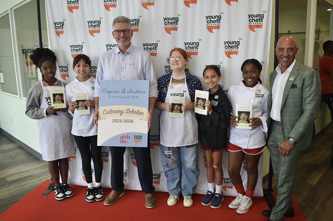 Sixth grader Jaleeyah, seventh grader Arianny, Young Chefs Academy owner Dennis O'Sullivan, seventh grader Meadow, fifth grader Ryker, fourth grader Mia, and Bill Villafranco, a trustee of the Virginia B. Toulmin Foundation, stand together as the group of Girls Inc. members graduates.