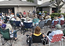A crowd gathers outside as the Driveway Drifters perform. The members pictured include Angie Eason, Gary Bowen, Debbie and Ron Fellman, Bill Green, Gary Eason, Lynn Cassell, Mike Lawless and Michael Cohen. One band member, Eugene Moleiro, was not in attendance.