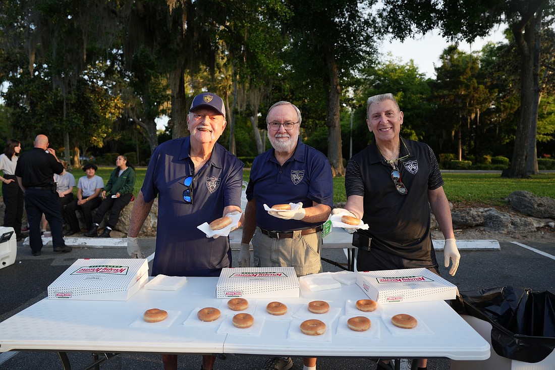 Ormond Beach Police Athletic League Board members Al Legg, Darrell Brock and Manny Manolas hand out donuts during the Ormond Beach Police Athletic League Donut Dash 5K on Saturday, April 18. Photo courtesy of Pauline Dulang/Ormond Beach Police