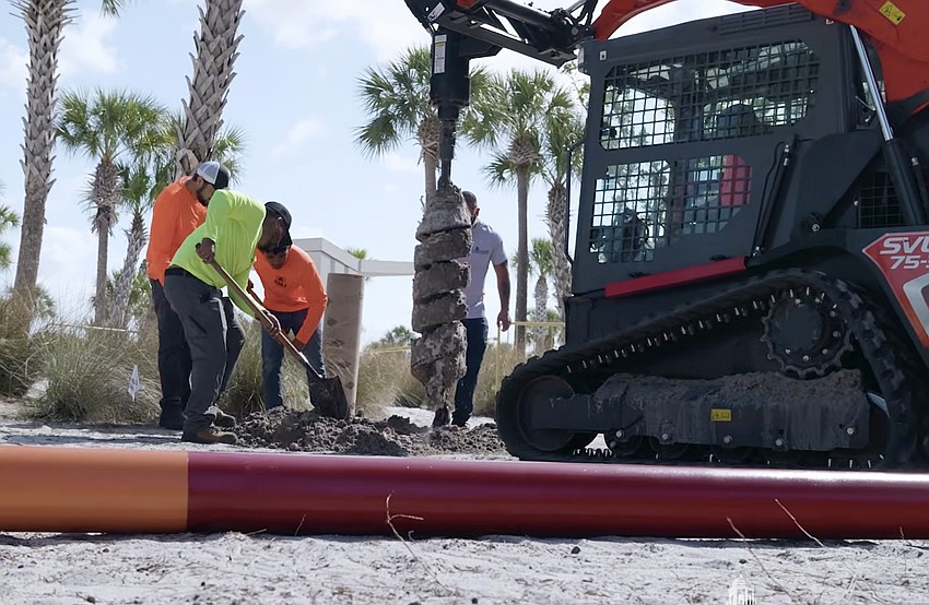 A storm surge pole being installed at Siesta Beach.