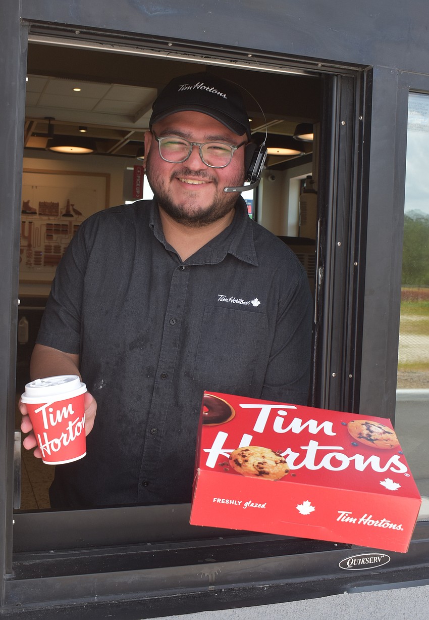 Ever Garza, a supervisor at Tim Hortons, is ready to greet customers with a smile in the drive through.