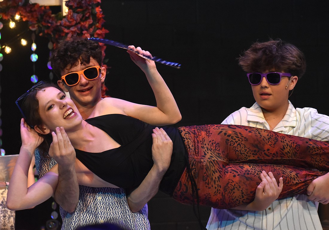 Zachary Papper and Dillon O'Callaghan carry Tatiana Moskalenko, who plays Tanya, as she sings "Does Your Mother Know" in The Out-of-Door Academy production of "Mamma Mia!"
