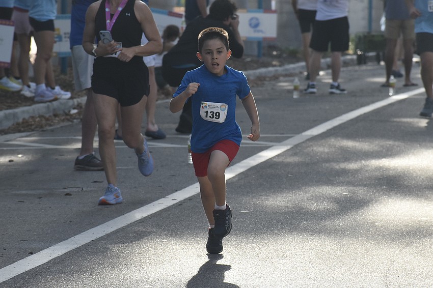 Sebastian Lara, 7, of Orange County, comes in for the finish line, with his grandmother, Sarasota's Inez Bly, also in the race.