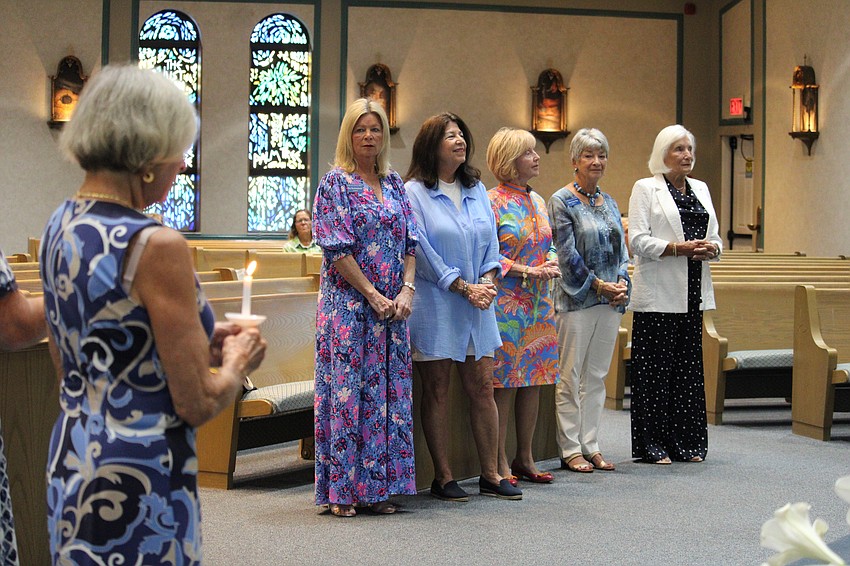 The outgoing board of the St. Mary, Star of the Sea, Catholic Church Women's Guild looks on after passing their candles to the incoming leaders. The board saw a complete turnover at the recent installation service.