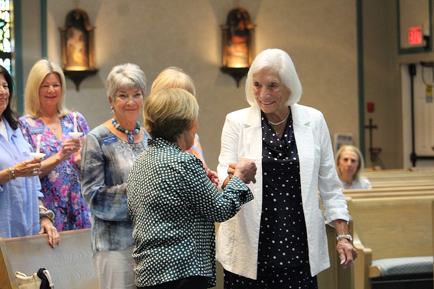 Treasurer Marilyn Davol passes her candle to Susan Hartrick.
