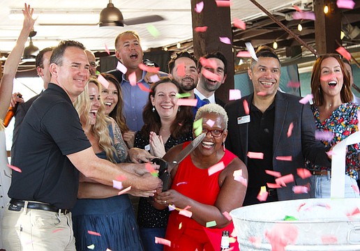 Surrounded by members of the Leadership Sarasota Class of 2026, staff from Save Our Seabirds and a cloud of confetti, Lisa Charles cuts the ribbon at the unveiling of an updated outdoor space at the bird sanctuary.