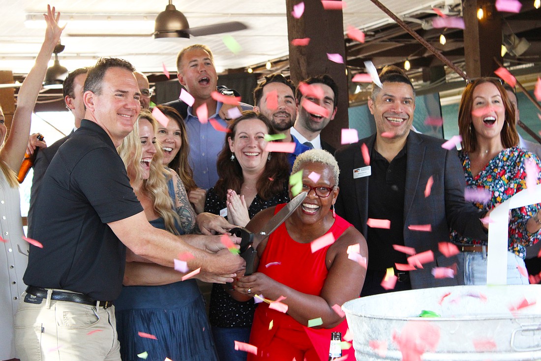 Surrounded by members of the Leadership Sarasota Class of 2026, staff from Save Our Seabirds and a cloud of confetti, Lisa Charles cuts the ribbon at the unveiling of an updated outdoor space at the bird sanctuary.