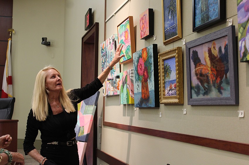 Coordinator Susan Phillips explains her thought process in finding shared color schemes and themes across featured artists to create the gallery for the Town Hall artists' reception and exhibition.