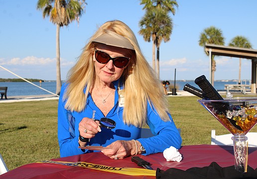 Susan Phillips, board chair of the Longboat Key Foundation and a Longboat Key Garden Club member, contemplatively peers through a clue-finding magnifying glass at the murder mystery-themed Dinner and a Movie fundraiser on April 24 at Bayfront Park. The event closed out this year's Arts in April programming.