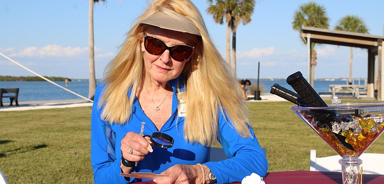Susan Phillips, board chair of the Longboat Key Foundation and a Longboat Key Garden Club member, contemplatively peers through a clue-finding magnifying glass at the murder mystery-themed Dinner and a Movie fundraiser on April 24 at Bayfront Park. The event closed out this year's Arts in April programming.