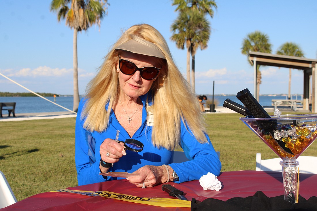 Susan Phillips, board chair of the Longboat Key Foundation and a Longboat Key Garden Club member, contemplatively peers through a clue-finding magnifying glass at the murder mystery-themed Dinner and a Movie fundraiser on April 24 at Bayfront Park. The event closed out this year's Arts in April programming.