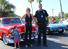 Jodene Moneuse shares a smile with Longboat Key Police Sergeant Lee Smith while Hagan Lyssy looks on at the first "Cops, Cars & Coffee" social event on April 25 at Whitney Plaza.