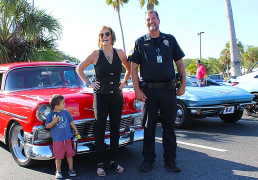Jodene Moneuse shares a smile with Longboat Key Police Sergeant Lee Smith while Hagan Lyssy looks on at the first "Cops, Cars & Coffee" social event on April 25 at Whitney Plaza.