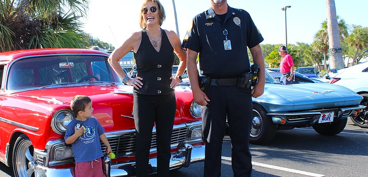 Jodene Moneuse shares a smile with Longboat Key Police Sergeant Lee Smith while Hagan Lyssy looks on at the first "Cops, Cars & Coffee" social event on April 25 at Whitney Plaza.