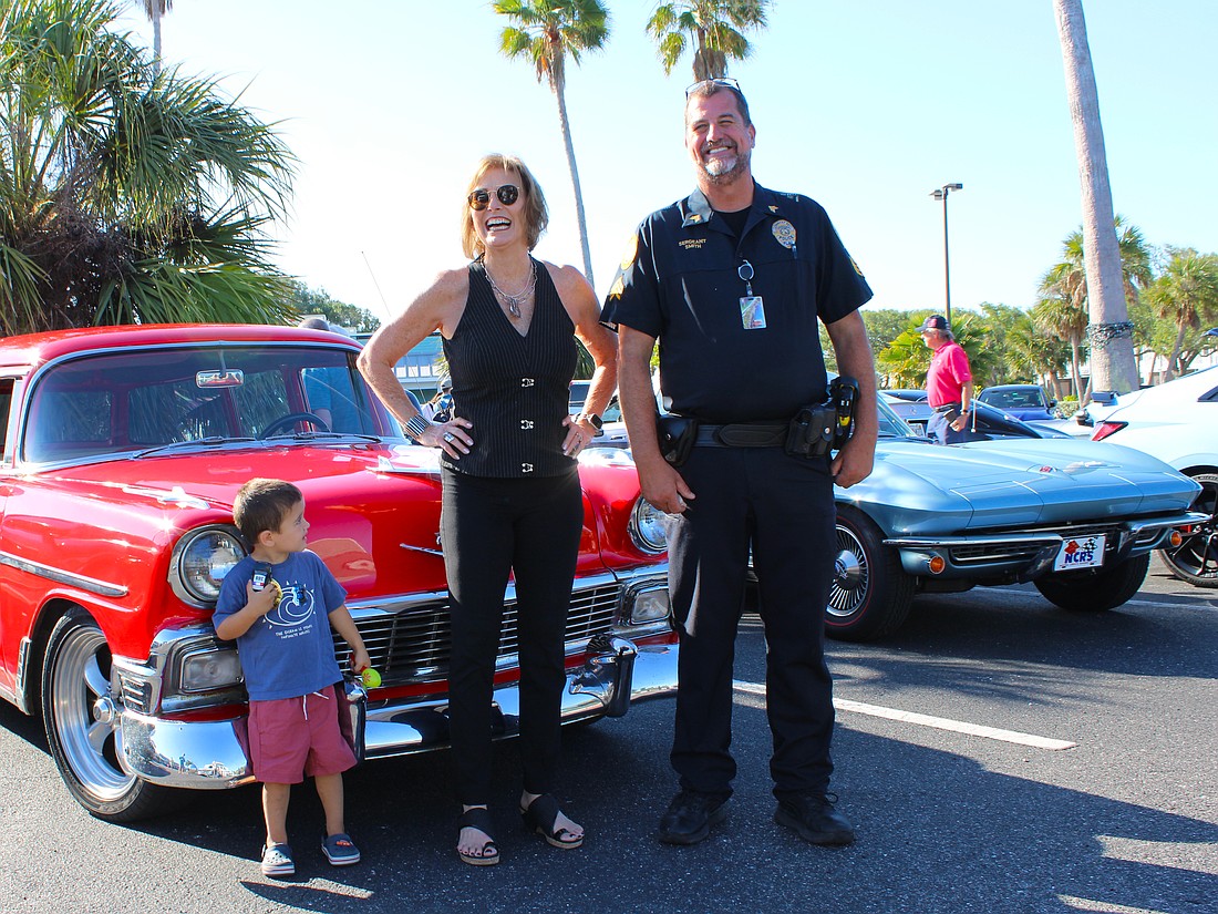 Jodene Moneuse shares a smile with Longboat Key Police Sergeant Lee Smith while Hagan Lyssy looks on at the first "Cops, Cars & Coffee" social event on April 25 at Whitney Plaza.