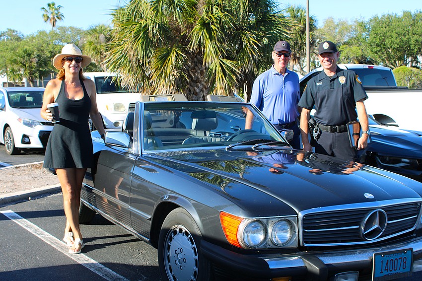Ellen and Hans Kirkegaard share the background on their 1986 Mercedes with Longboat Key Police officer Simon Maple at the island's first Cops, Cars and Coffee meetup April 25 at Whitney Plaza.