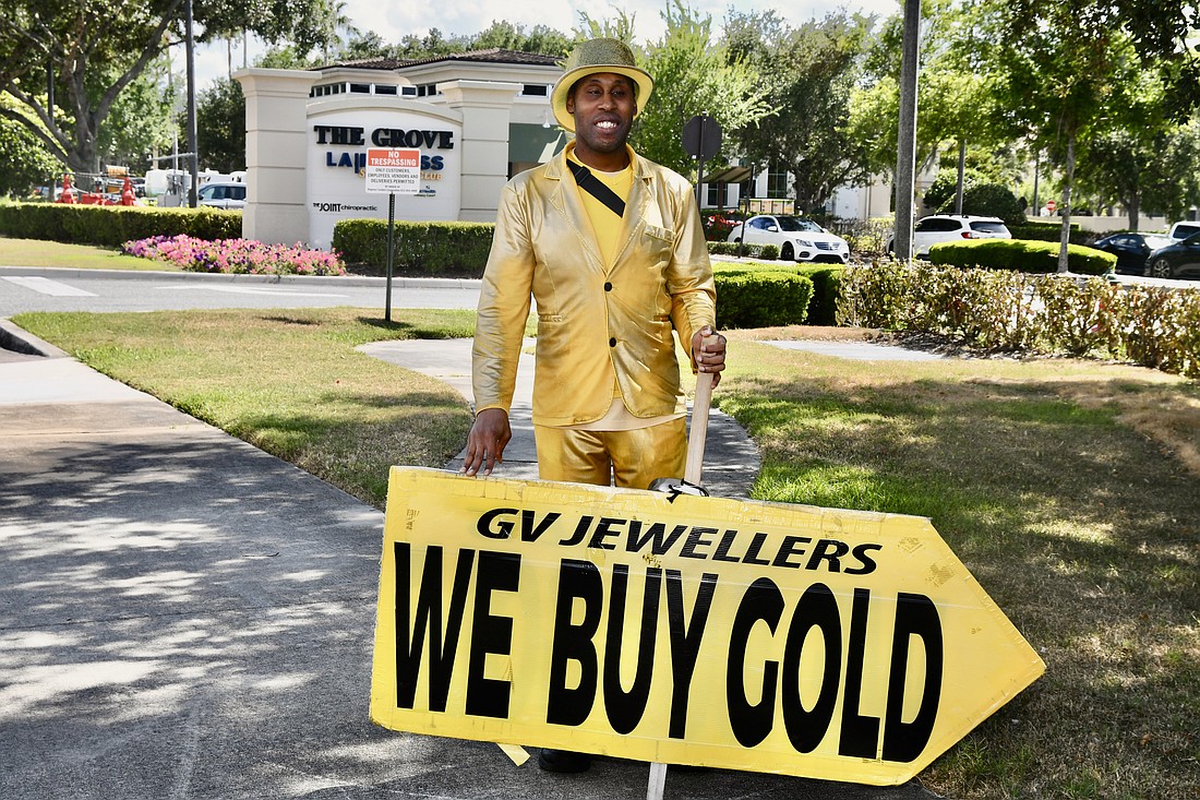 Erik Morgan, aka Mr. Gold, loves to spread happiness and cheer as he waves his “We Buy Gold” sign.