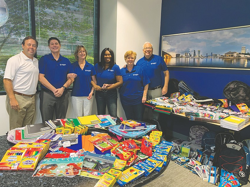 From left, Cogent Bank First Coast Market President Phil Bravo and bank associates Paul Naylor, Jennifer Allen, CeCe Harrigan, Allison Johnston and Scott Flanders with school supplies collected for students at Twin Lakes Academy Elementary.