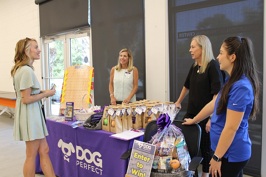 Linda Emery, Tracy Bell and Grace Harvey share information about DOGPerfect's products and services for pets. The newly franchising business sponsored the Off the Clock social on April 29 at the Humane Society of Sarasota County facilities.