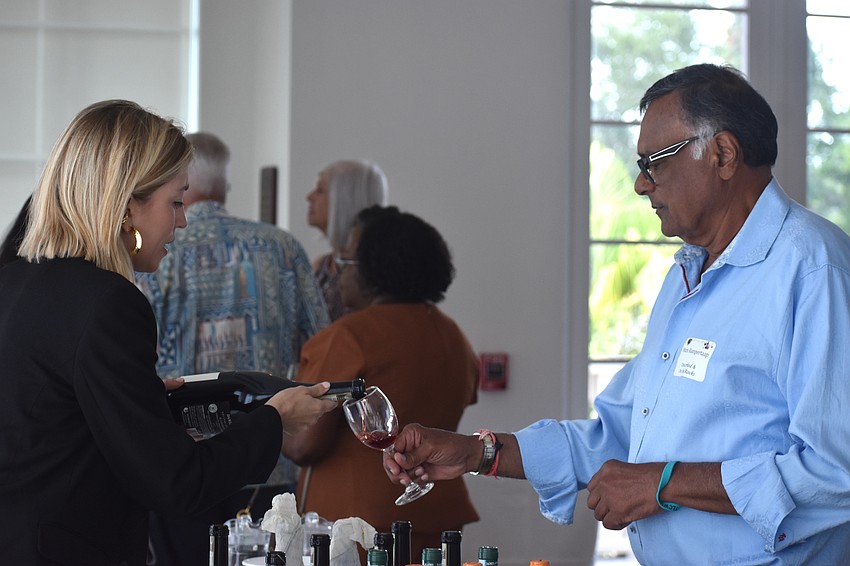 Chiara Damilano, a fourth generation member of Damilano Winery, pours wine for Muni Rampertaap to taste test at the Uncorked & On the Rocks fundraiser.