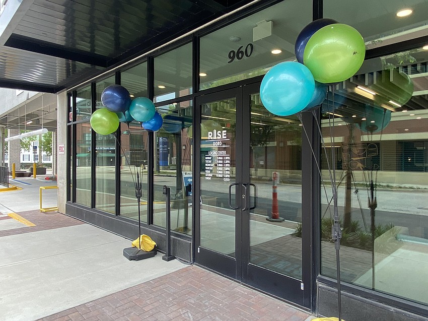 Balloon-like decorations have been placed outside the Rise Doro apartments leasing office, which is open. A June 4 private opening of the project is planned.