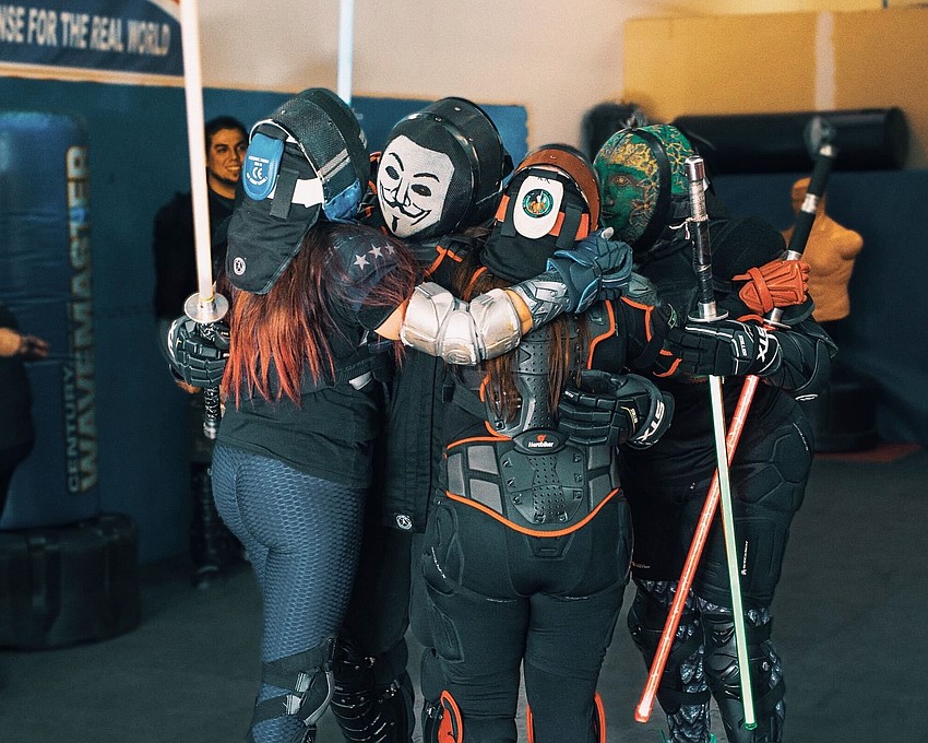 Members of The Saber Legion hug after competing in a light saber duel. Members of The Saber Legion hug after competing in a light saber duel.