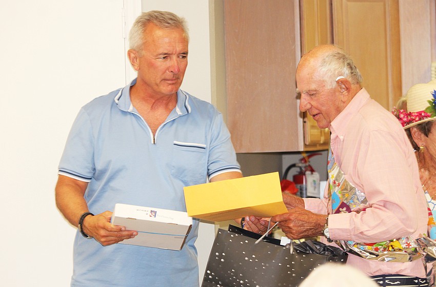 John Katko, a former U.S. representative, presents veteran Don Schultz with an American flag flown above the Washington D.C. Capitol building for his surprise 90th birthday celebration following the Kentucky Derby watch party on May 2 at Windward Bay.