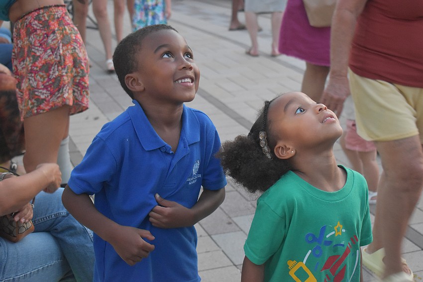 Parrish's Keylan Laws, 6, and Olivia Laws, 5, look up in awe at stilt walker Natasha Eriksen at the Agave Bandido Cinco de Mayo celebration.
