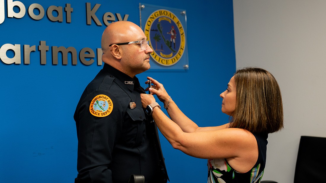 Officer Jorge Castro had his badge pinned onto his uniform by his wife, Melissa Castro, after he was sworn in as the newest Longboat Key Police Department officer Wednesday, May 6, 2026.