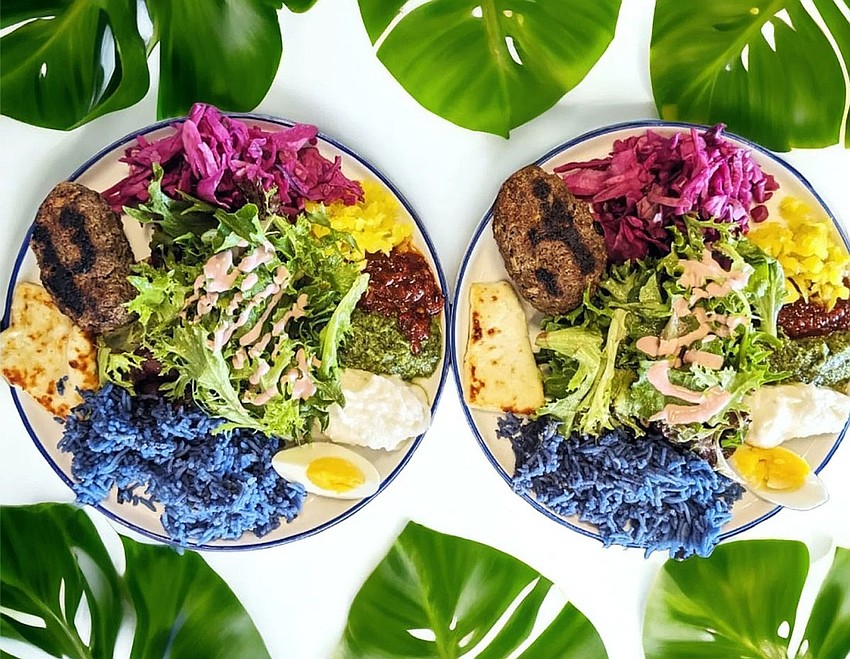 Rainbow Bowls come with hummus, tahini, grilled halloumi, coconut blue rice, slaw, banana pepper, greens, harissa, sesame and egg.