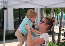 Parker Hippich, 12 months, gets a lift from mom, Tessa Hippich, during Petals and Poses on Saturday at Waterside Place.