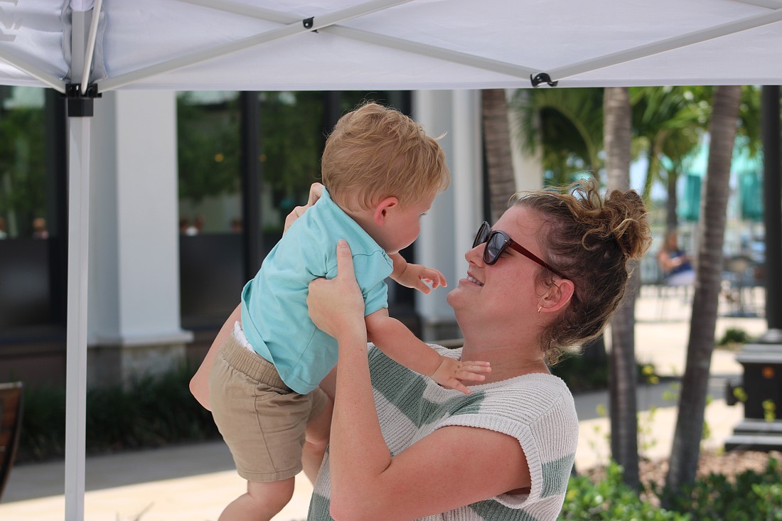 Parker Hippich, 12 months, gets a lift from mom, Tessa Hippich, during Petals and Poses on Saturday at Waterside Place.