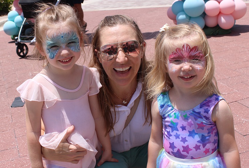 Sarasota's Katy Akers lets daughters Vivi, 4, and Lulu, 2, show off the face painting they had done at the Petals and Poses event.