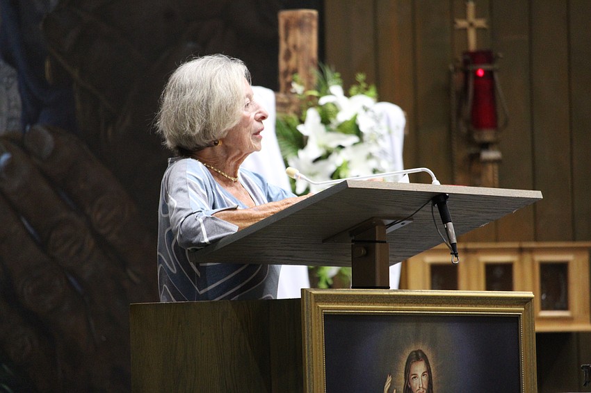 Barbara Sikora, president of the Women's Guild at St. Mary, Star of the Sea, Catholic Church, sings Bonnie Schneider's praises as this year's May crowning honoree.