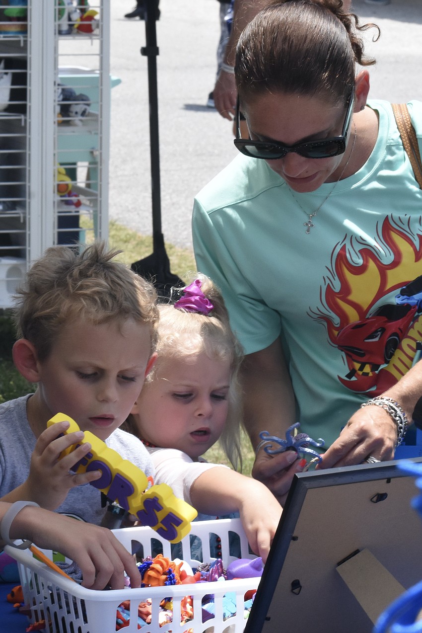Blaize Johnson, 6, Iris Johnson, 4, and their mother Rebecca Johnson explore some items for sale.