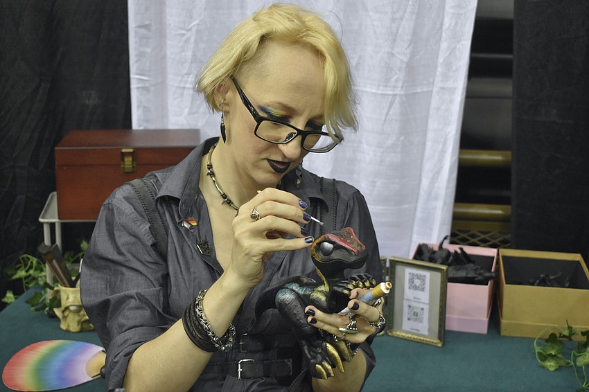 Anya Grady, of Spider Eyes, paints a dinosaur