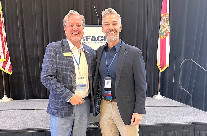 Greater Sarasota Chamber of Commerce Vice President Ed Hill (left) receives the Florida Association of Chamber Professionals Professional of the Year Award from Noel Martinez of the Palm Beach North Chamber of Commerce.