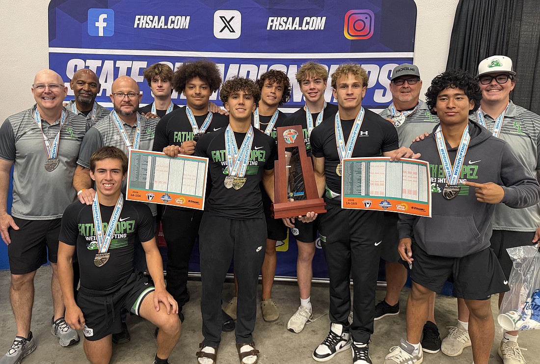 State champs Joseph Abrantes and Maverick Grimm hold up Father Lopez's runner-up trophy for the Class 1A Olympic competition. The Green Wave had eight lifters qualify for state. Courtesy photo