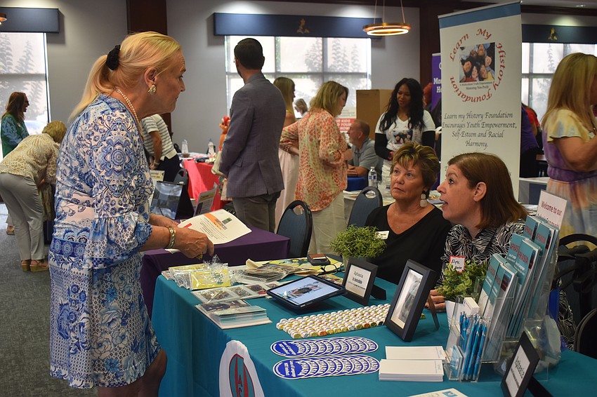 Glo Reber, a member of Sisterhood for Good, learns about Aphasia Community Center from board members Becky Reese and Elyse Gordon.