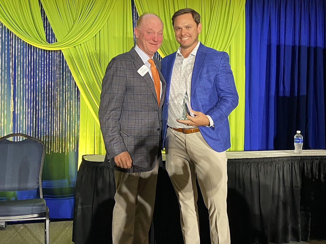 Corner Lot CEO Andy Allen, right, accepts Junior Achivement of North Florida’s Thompson S. Baker “Solid as a Rock” Award from Rob Sandlin, former JANFL board member and retired president of Florida Rock & Tank Lines, on May 13 at the Adam W. Herbert University Center at the University of North Florida.