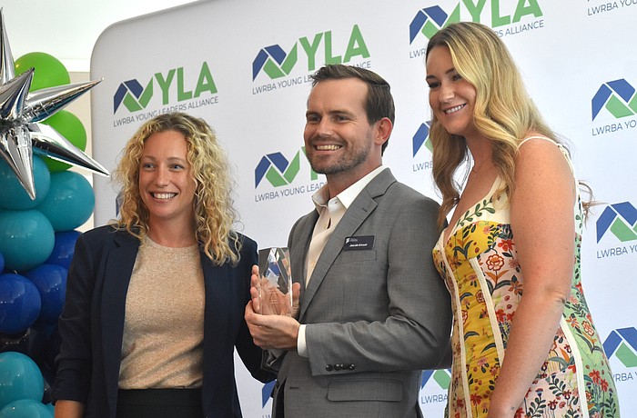 Brittany Lamont and Nicole Hackel congratulate Jacob Kinsel of the Manatee Education Foundation as he is announced as the winner of the "Next Gen" award at University Park Country Club May 13.