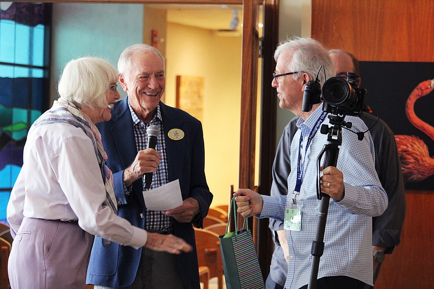 Anita Pihl and Lou Newman share a laugh as Dick Forester has to set aside his duties photographing the Plymouth Harbor photographers' reception to collect his first-place award for his piece, 