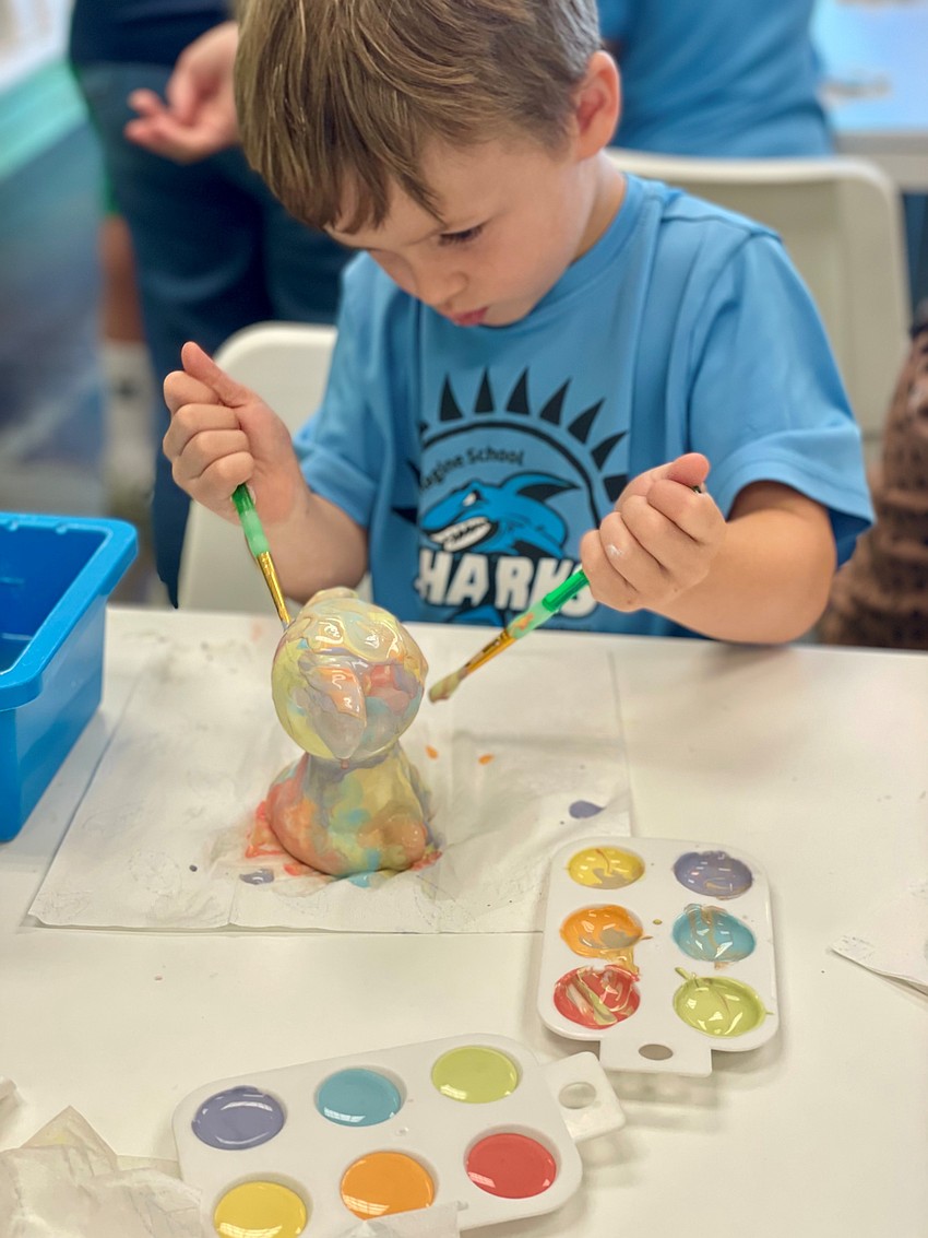 A young artist concentrates on the details at Arts A Blaze, where simple brushstrokes turn everyday ceramics into one-of-a-kind creations.