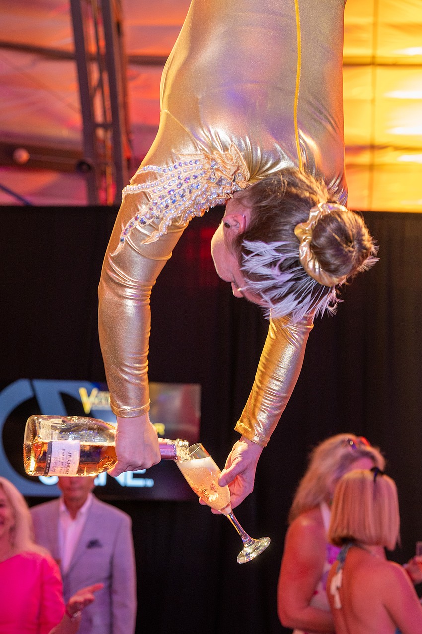 A circus performer serves champagne to guests.
