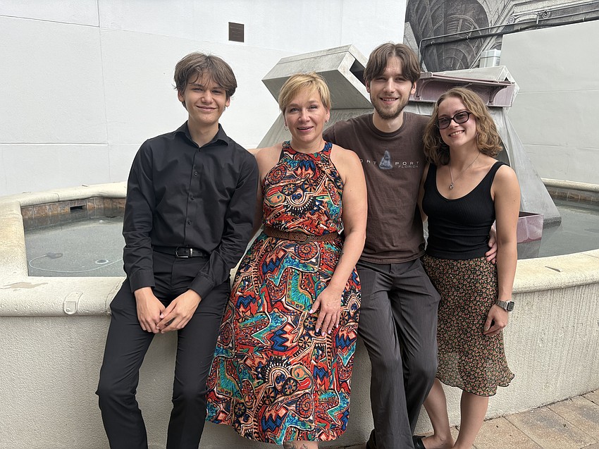 Andrii Padkovskyi, his mother Tamara Doroshenko, Yurii Padkovskyi and Yurii's partner, Valeriia Dulyba pose in front of a fountain on Main Street in Sarasota.